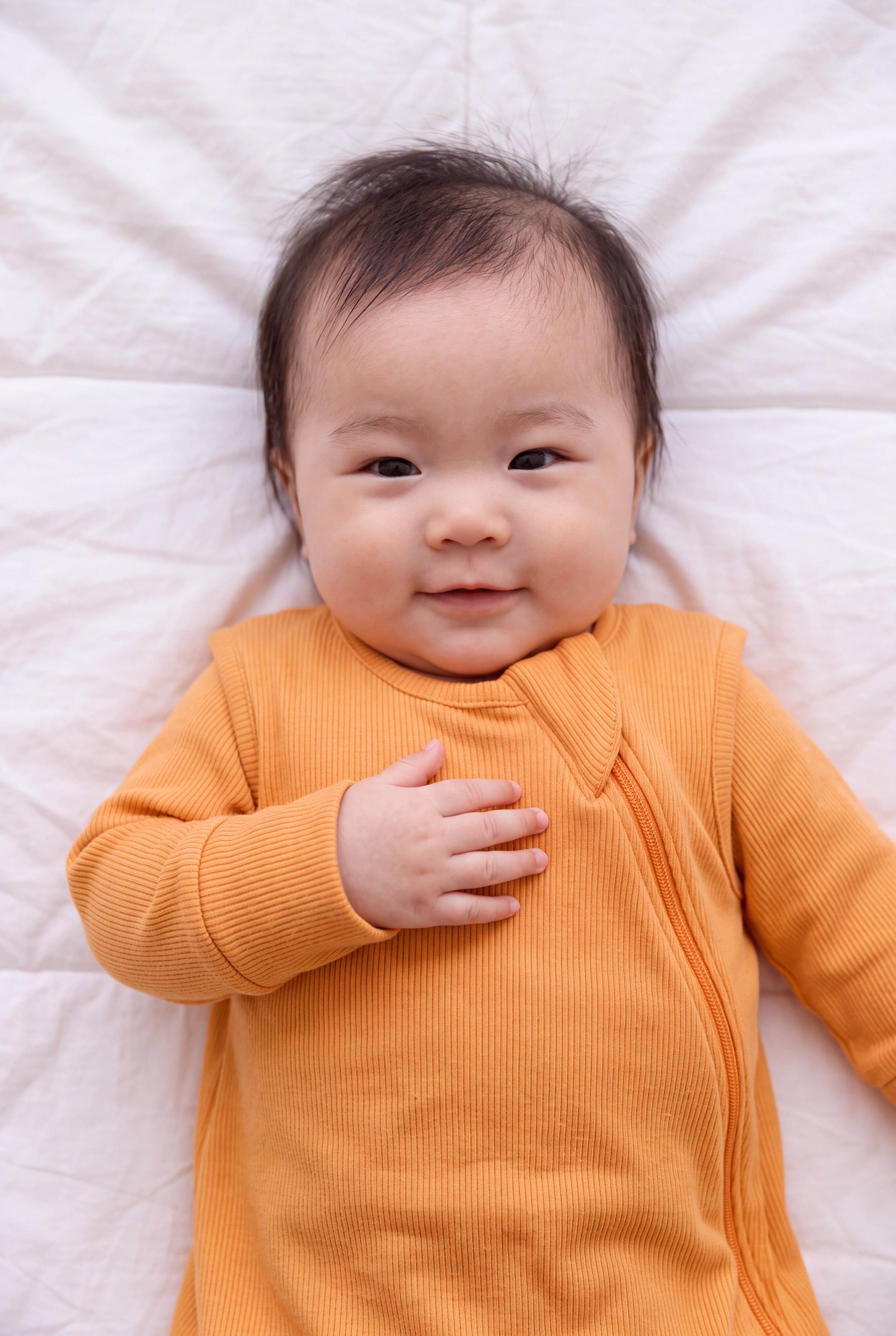 Close-up of the Amber ribbed bamboo sleep bag zipper and shoulder flap on a smiling baby